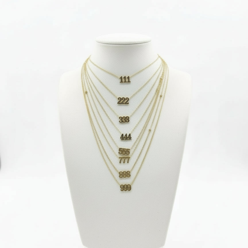 Set of gold necklaces on a white mannequin bust with visible chain lengths.