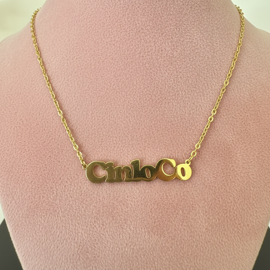 Gold necklace with a customizable name plate pendant on a mannequin bust.