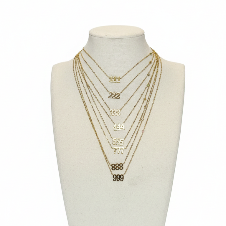 Set of gold necklaces on a mannequin bust against a white background