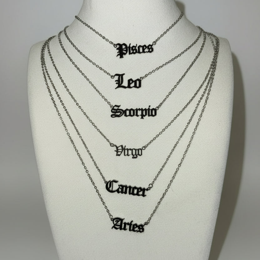 Necklaces with zodiac symbols on a mannequin bust against a white background