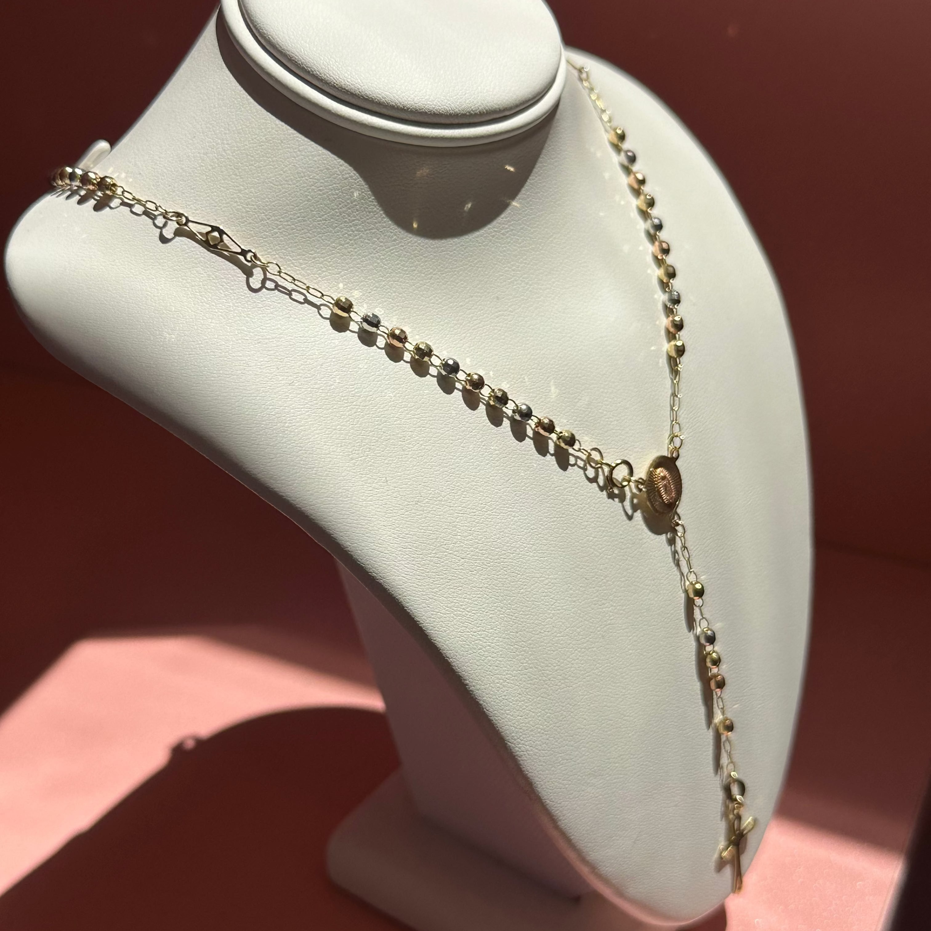 Necklace on a white mannequin bust against a brown background