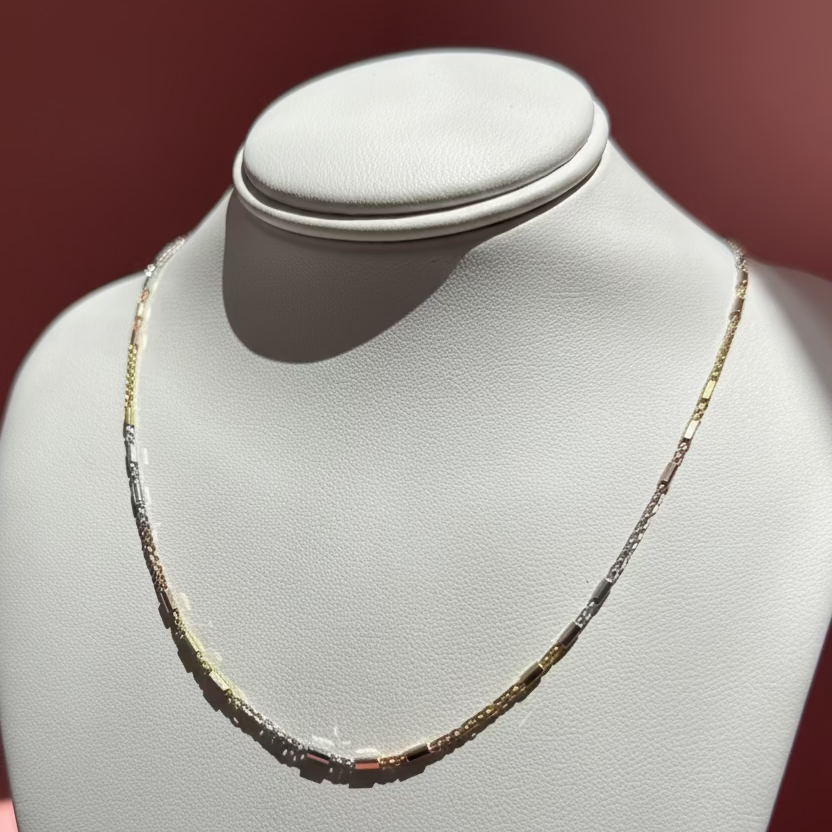 Solid Gold Necklace on a mannequin bust against a pink background