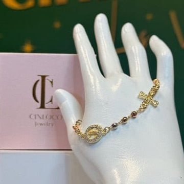 Gold bracelet on a mannequin hand with Cinlo Co jewelry box in the background