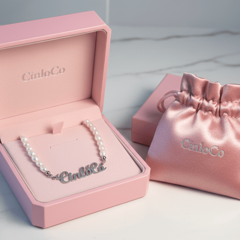 Pink jewelry box with a bracelet inside, next to a matching pink drawstring bag on a light gray background.
