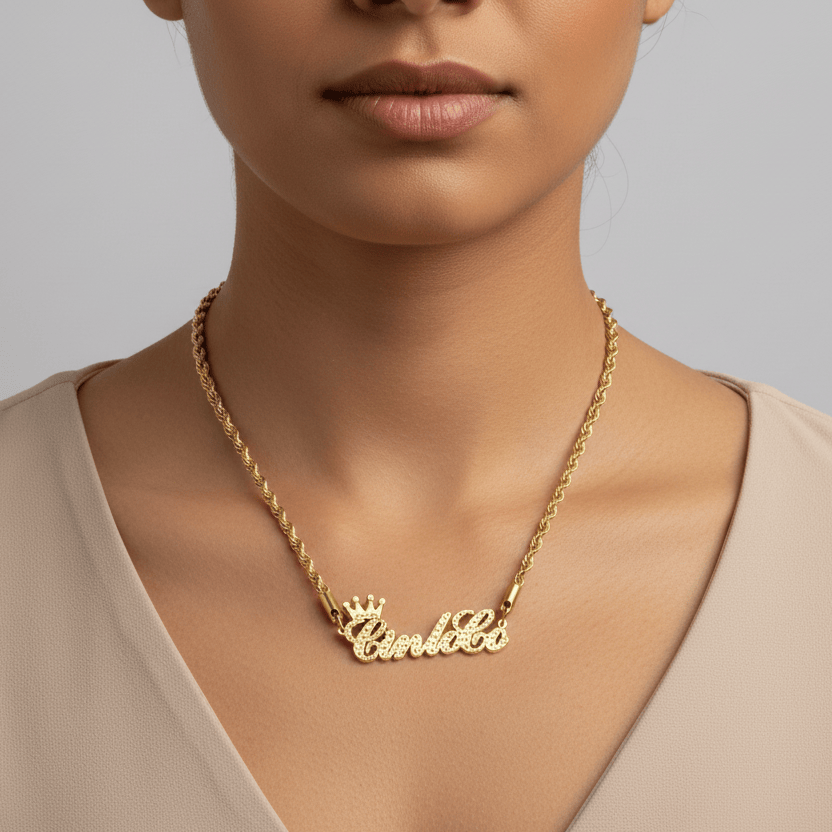 Gold necklace with 'Crown' and 'Caroline' pendant on a neutral background
