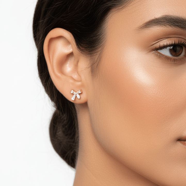 Close-up of a woman wearing a butterfly-shaped earring on a plain background