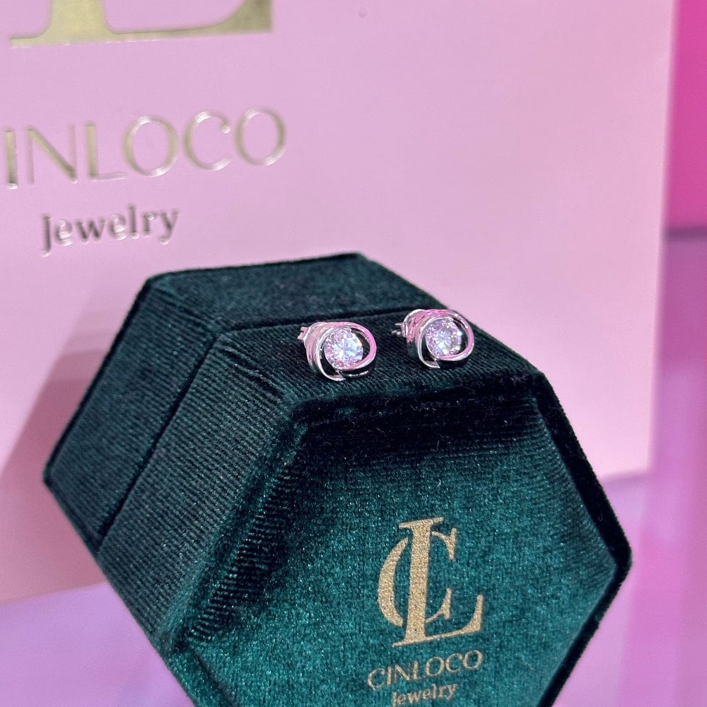 Green jewelry box with CINNICO earrings on a pink background