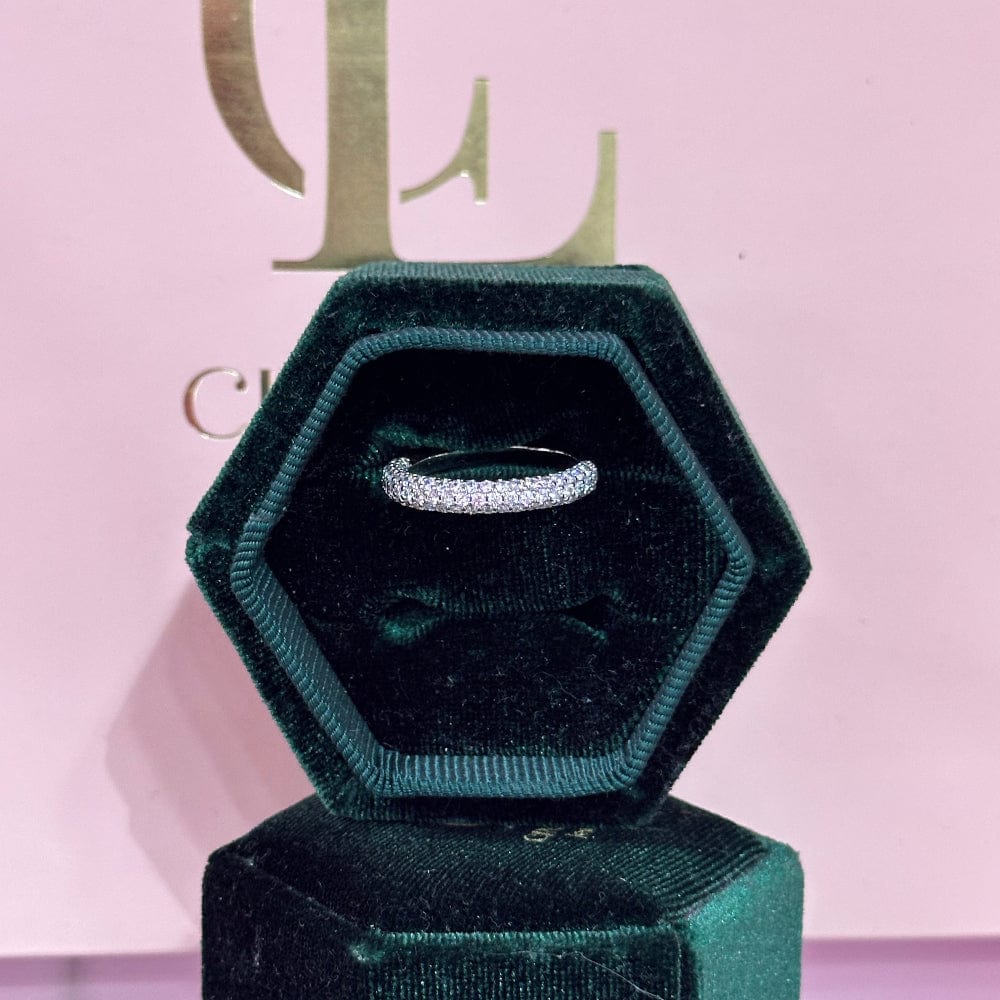 Diamond ring in a green velvet box on a pink background