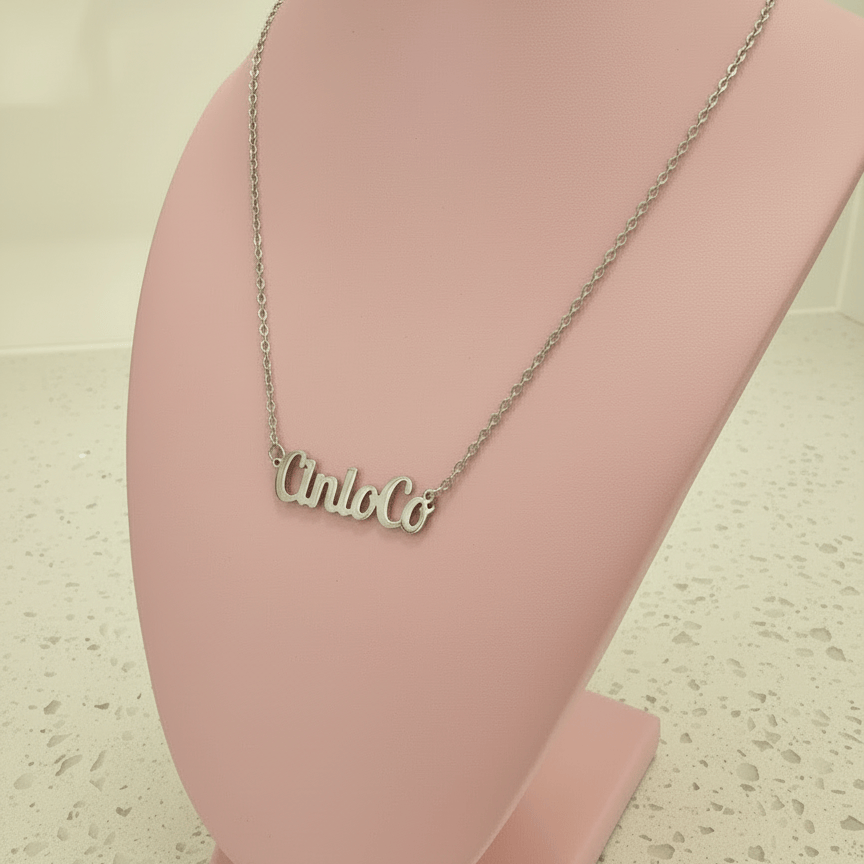 Necklace with 'Lindo Co' pendant on a pink stand