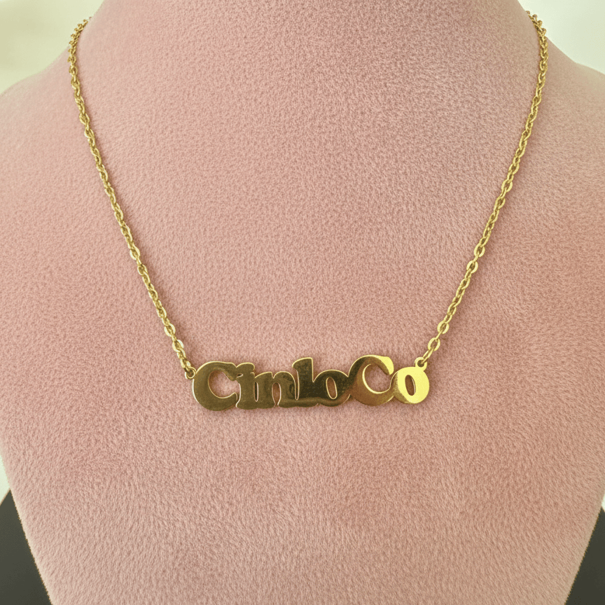 Gold necklace with a customizable name plate pendant on a mannequin bust.