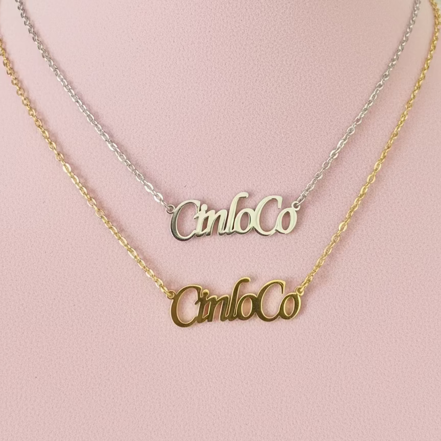 Two gold nameplate necklaces on a pink mannequin bust.