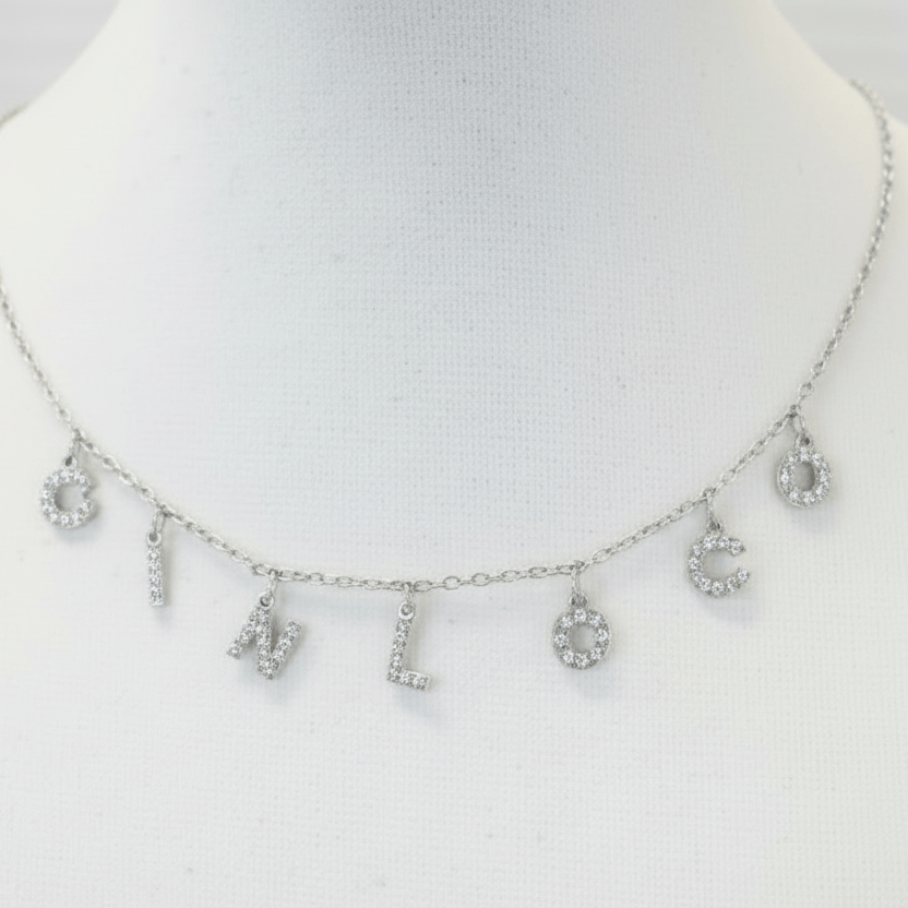 Silver necklace with floral pendants on a mannequin bust against a white background