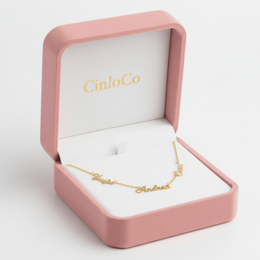Gold bracelet with 'Andrea' engraving in a pink jewelry box with 'CinloCo' branding.