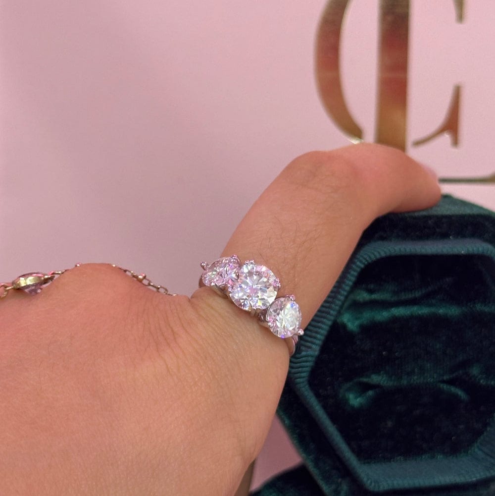 Diamond ring on a finger with a pink box in the background