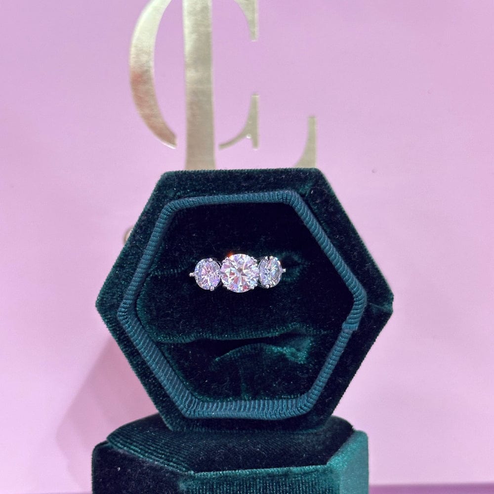 Diamond ring in a green velvet box on a pink background