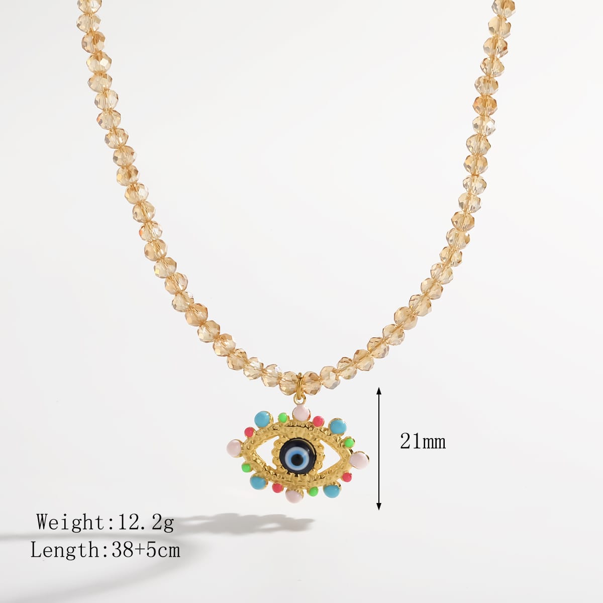 A gold-toned beaded necklace with a colorful evil eye pendant, shown on a white background with text indicating weight, length, and 21mm height.