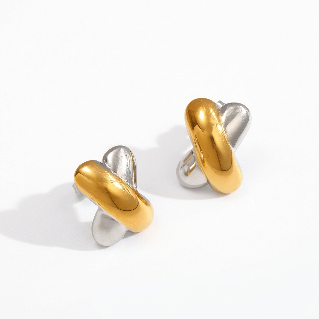 Gold and silver X-shaped earrings on a white background