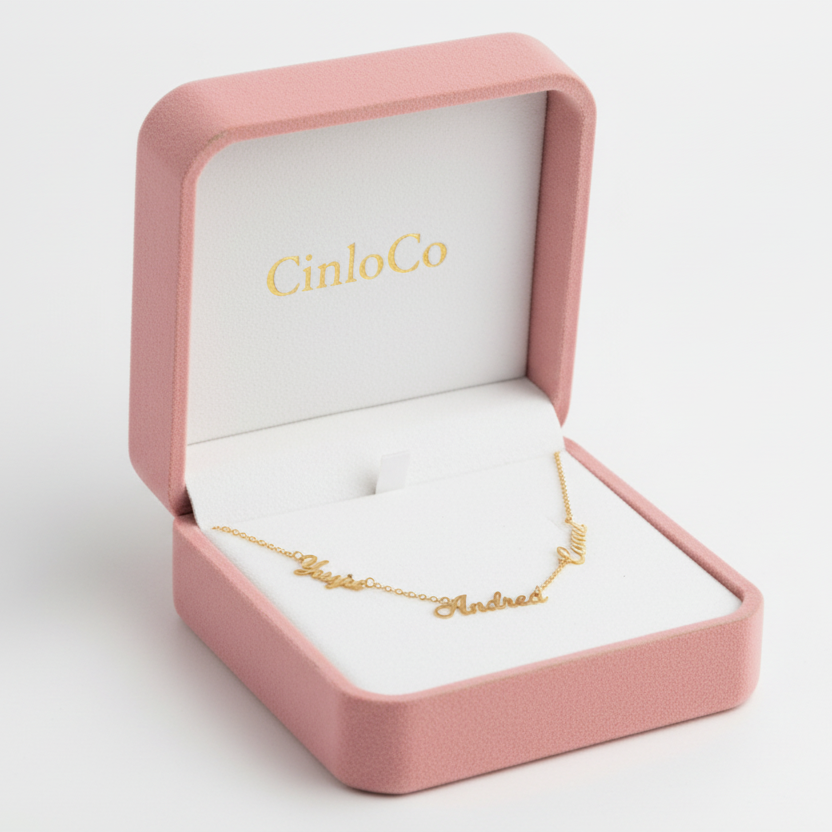 Gold bracelet with 'Andrea' engraving in a pink jewelry box with 'CinloCo' branding.