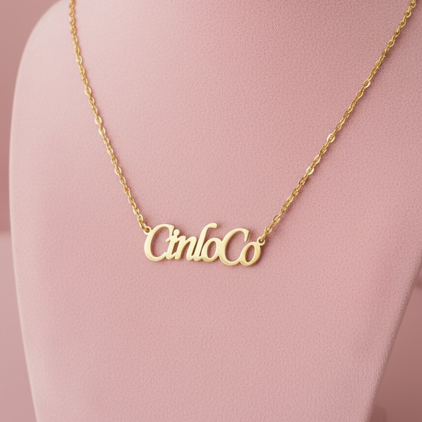 Gold necklace with custom name plate pendant on a black background