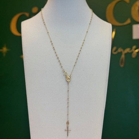 Gold necklace on a mannequin bust with a green background