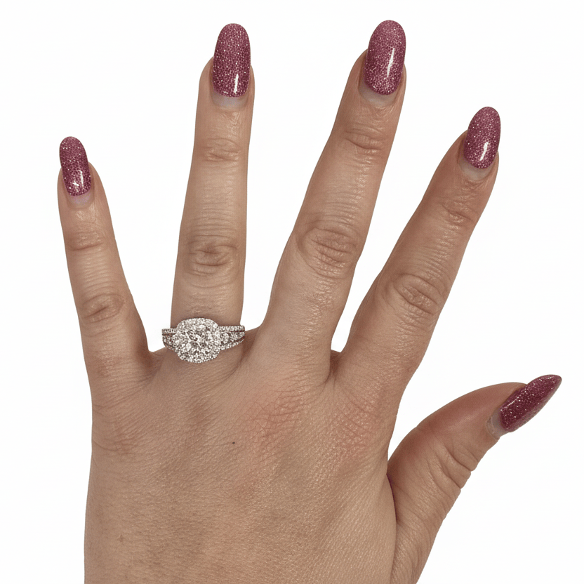 Hand wearing a diamond ring with pink nail polish on a white background