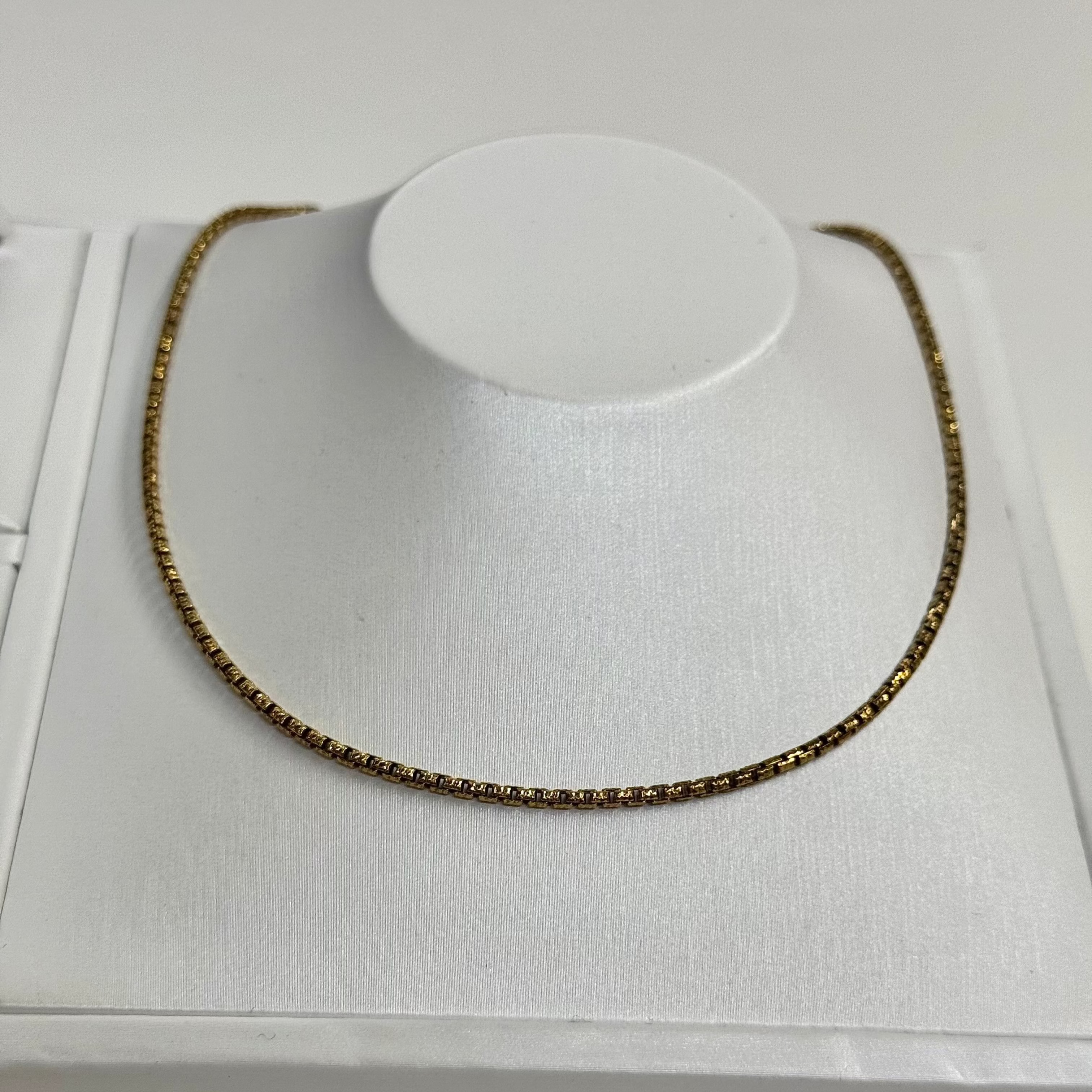 Necklace on a white mannequin bust with a white background