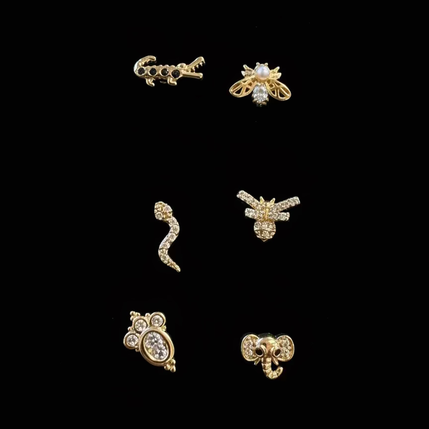 Set of gold earrings on a white display card with a dark background