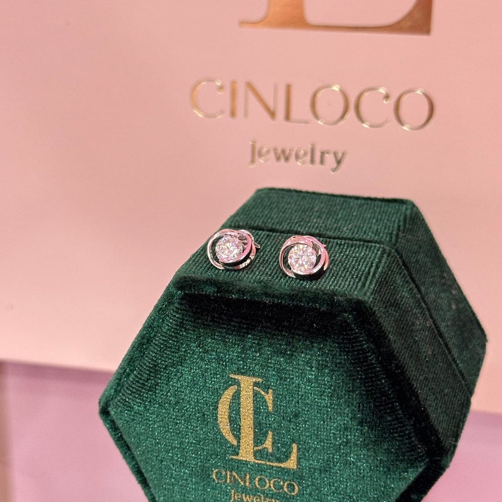 Green jewelry box with Cincojo earrings on a pink background