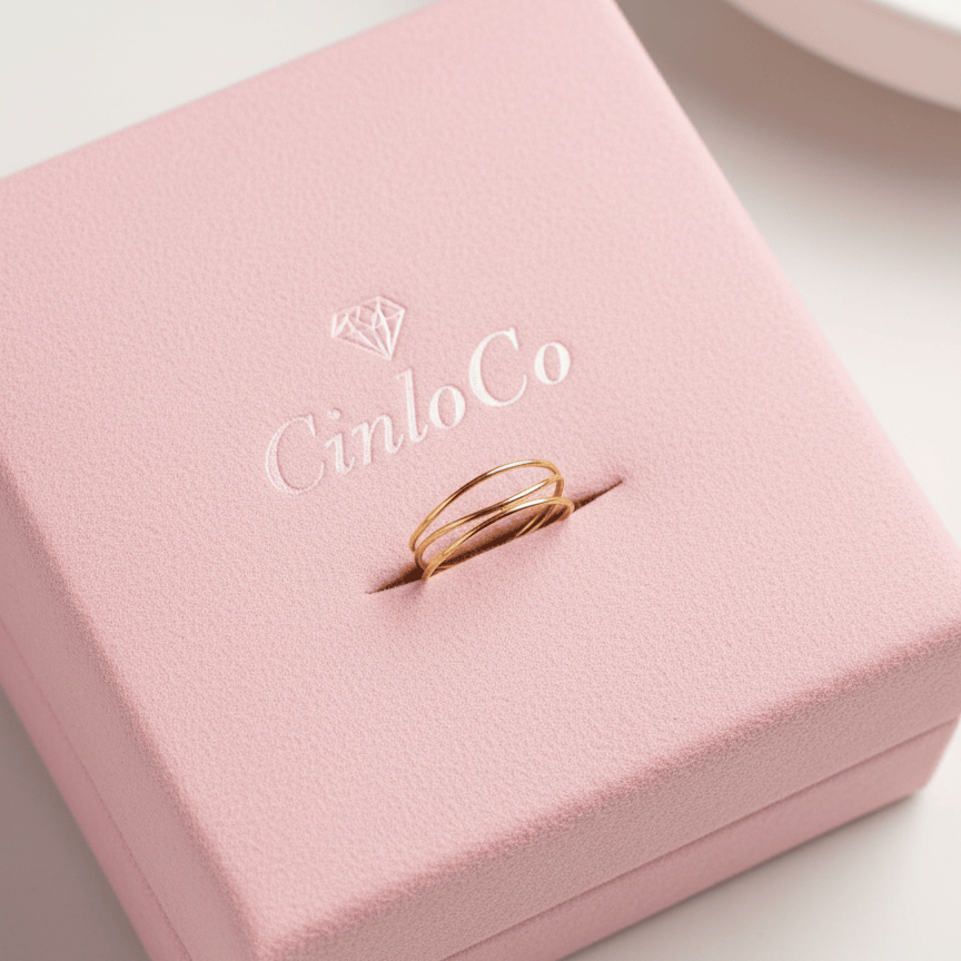 Pink jewelry box with a gold ring inside, featuring the brand 'Cinlo Co'.
