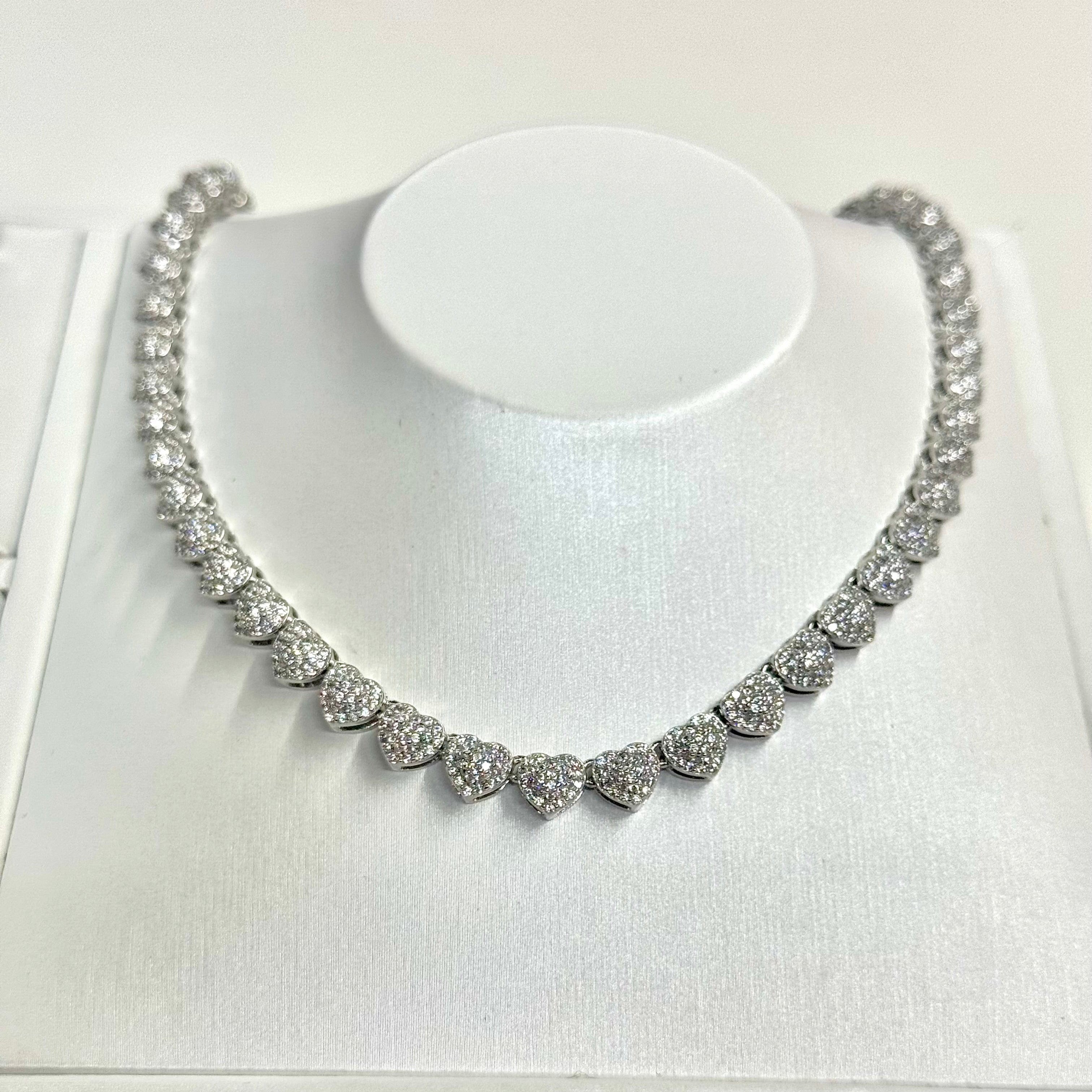 Silver necklace on a white stand with a white background