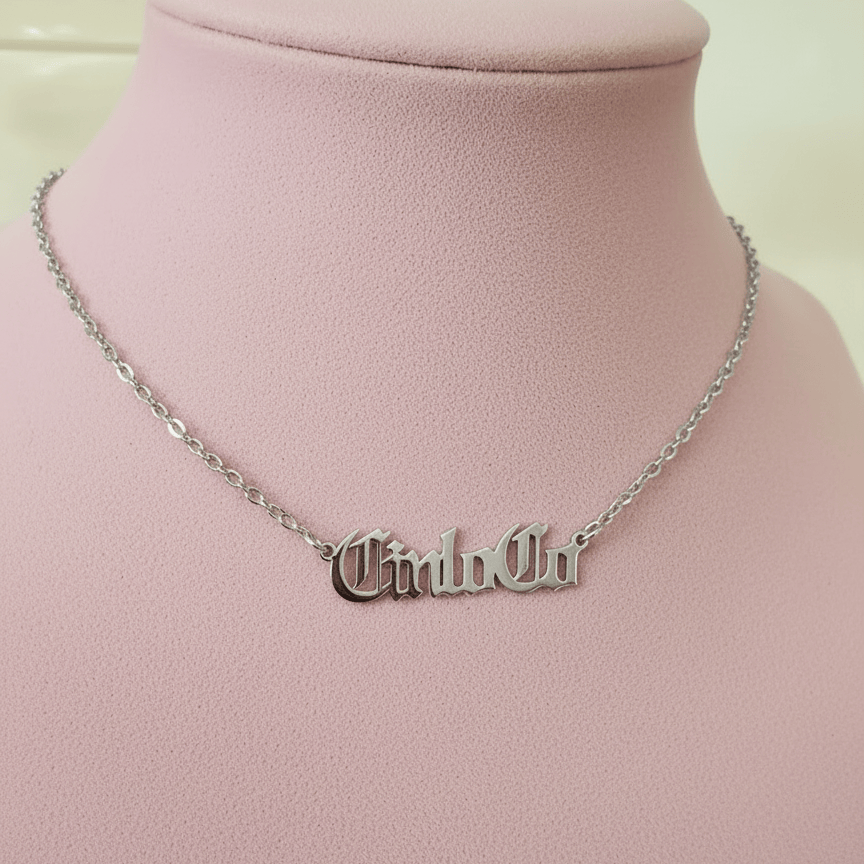 Necklace with CUSTOM NAME PLATE pendant on a mannequin bust against a pink background