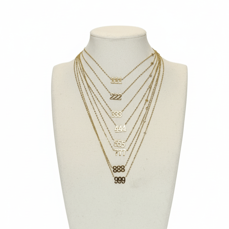 Set of gold necklaces on a mannequin bust against a white background