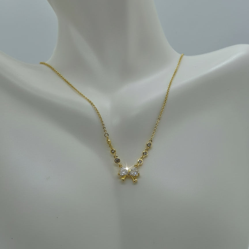 Gold necklace with a small pendant on a mannequin bust against a white background