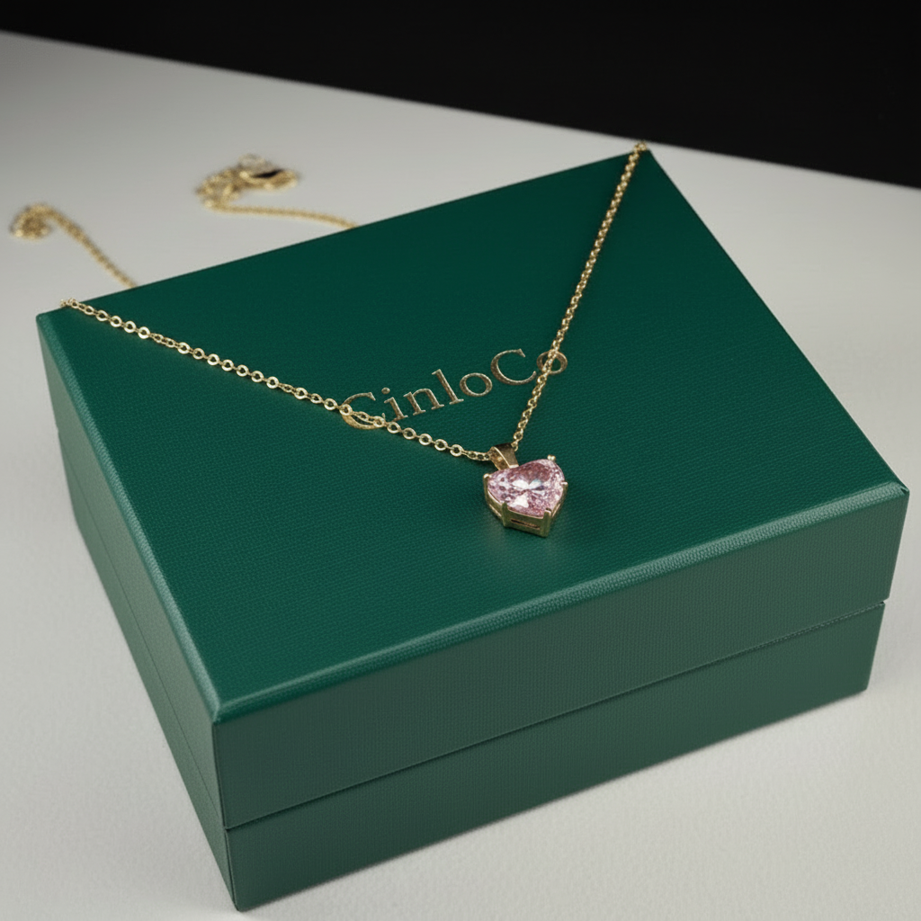 Gold necklace with a pink heart pendant on a blue CinloC box.