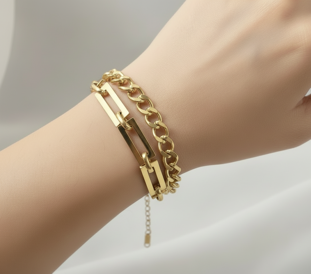 Gold chain bracelet on a pink surface with 'CinloCo' branding.
