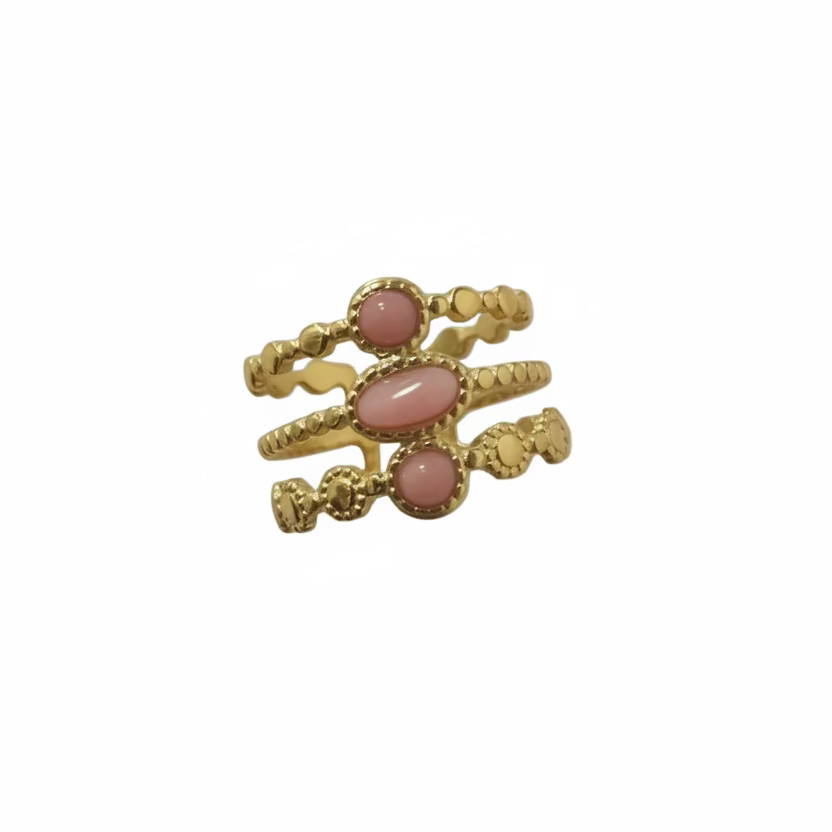 Gold ring with pink stones on a pink background
