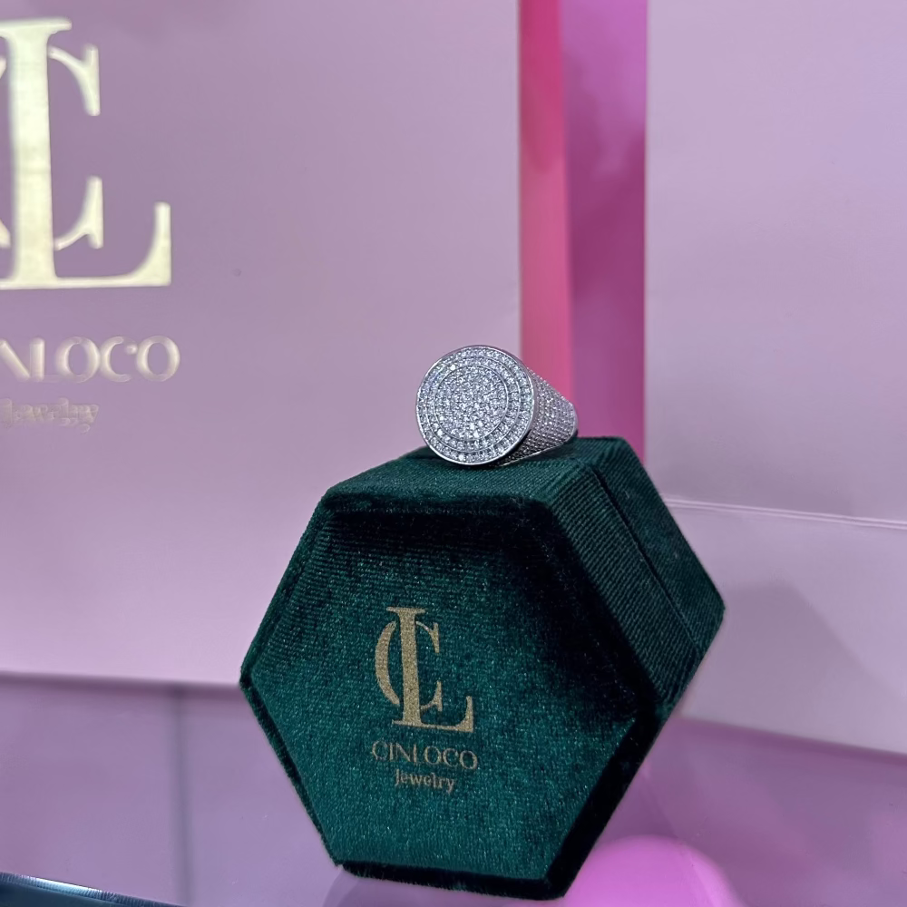 Green jewelry box with a ring on top, featuring the brand 'CINLOCO', against a pink background.