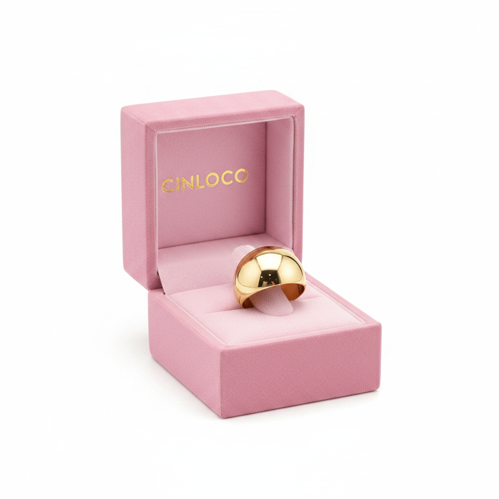 A gold dome ring displayed inside an open pink jewelry box with the brand name CINLOCC visible on the inner lid, set against a plain white background.