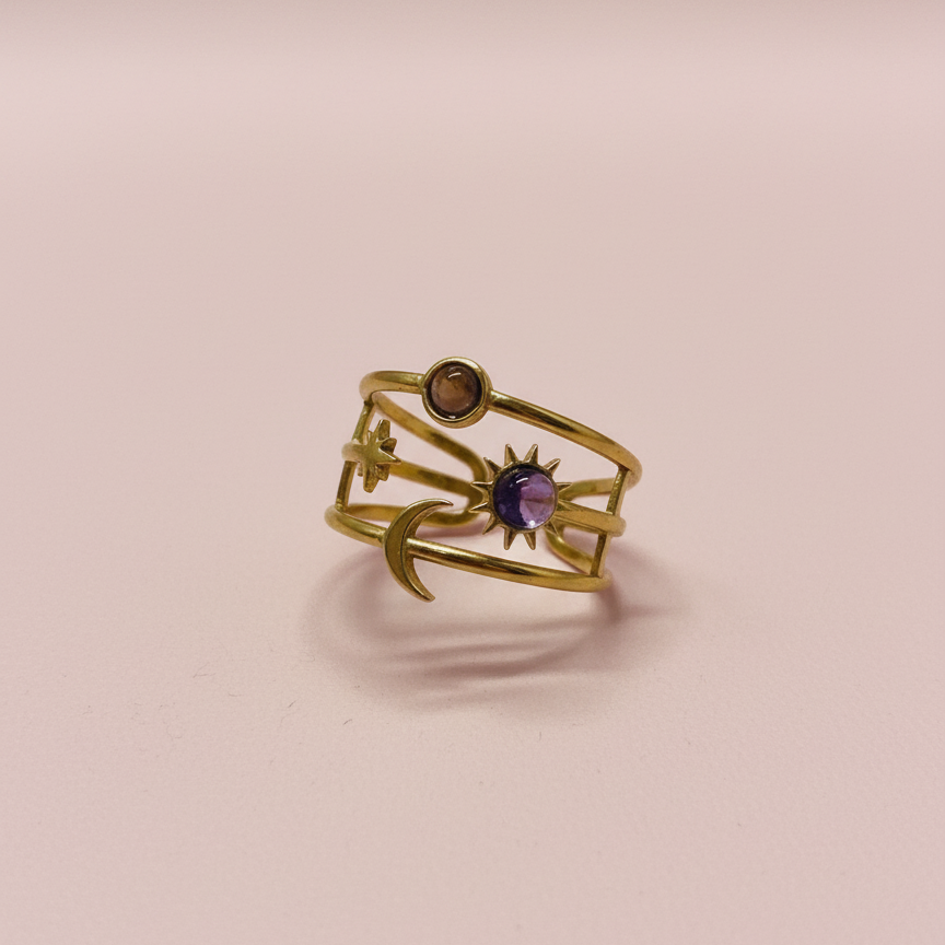 Gold ring with gemstones on a pink background